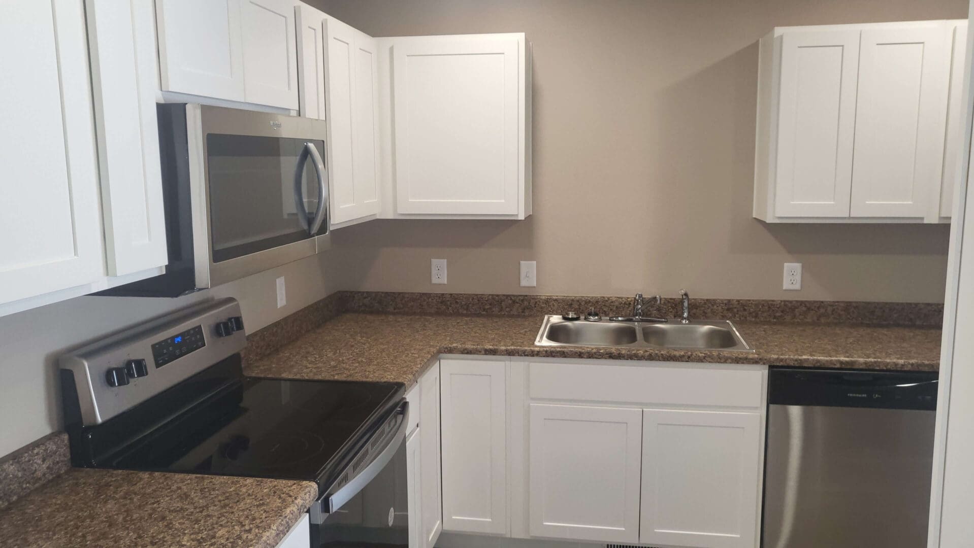 Modern kitchen with white cabinets and appliances.