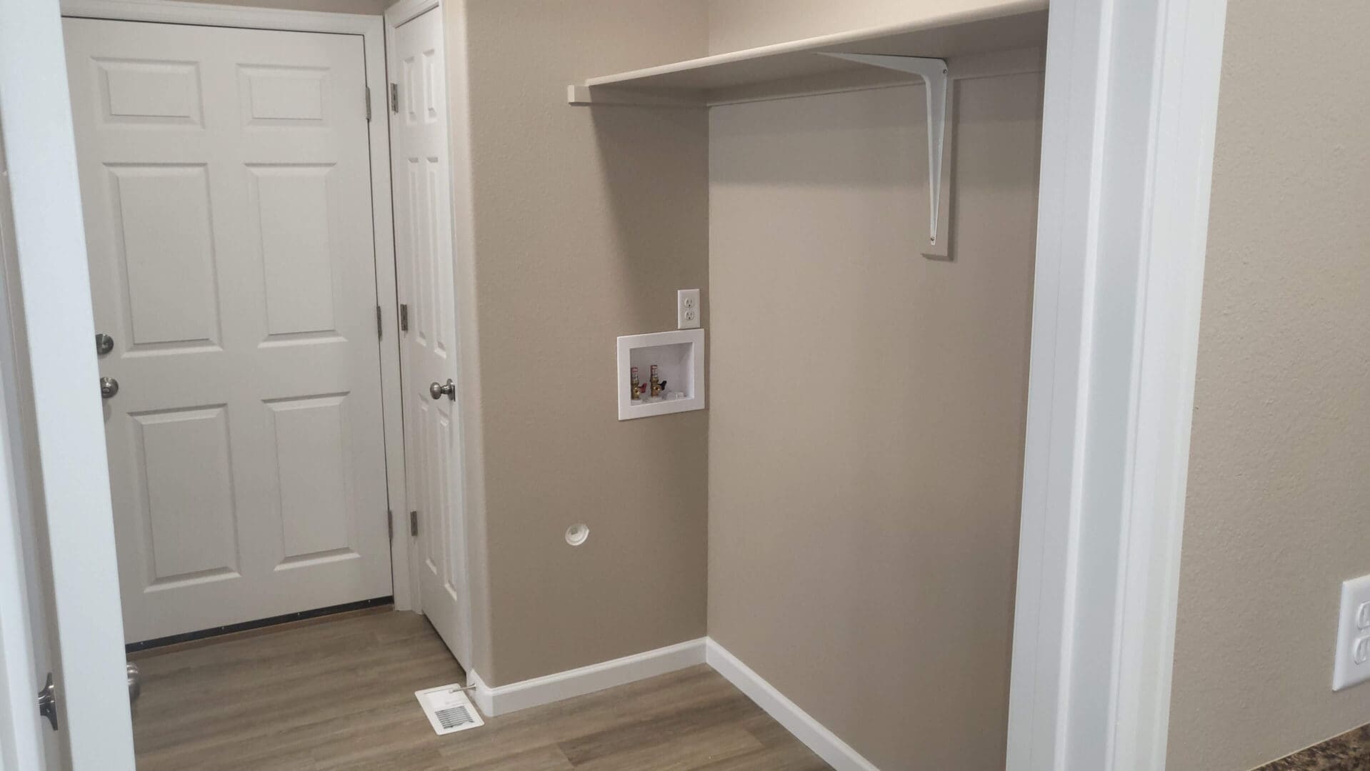 Laundry room with shelf and hookups.