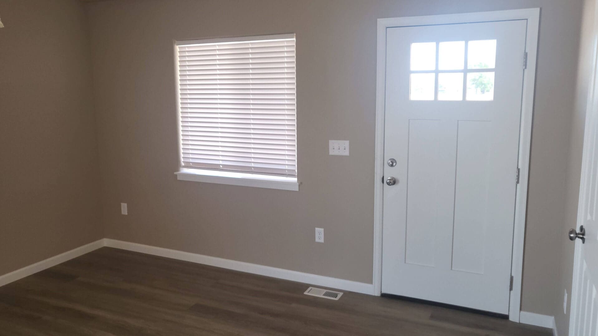 Empty room with window and white door.