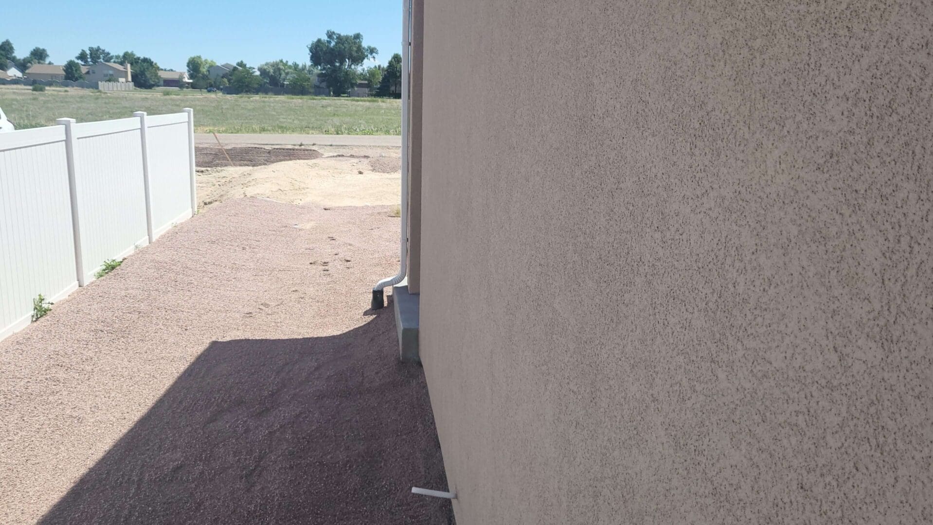 Side of house with gravel path.