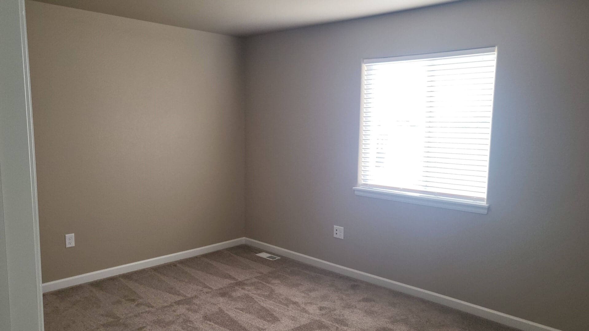 Empty room with beige walls and carpet.