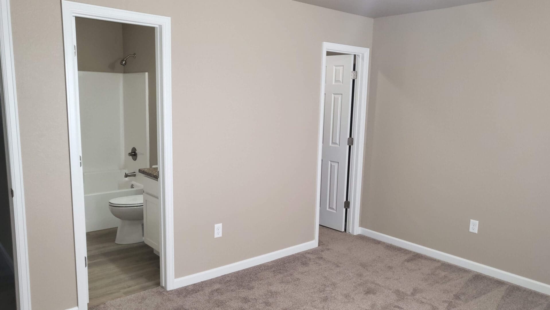 Empty room with bathroom and closet doors.