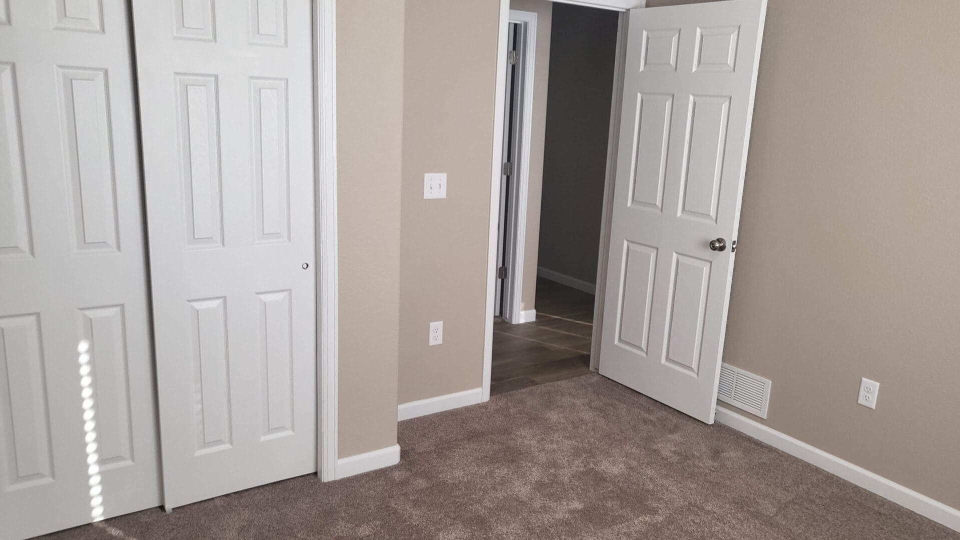 Empty room with carpet and open door.