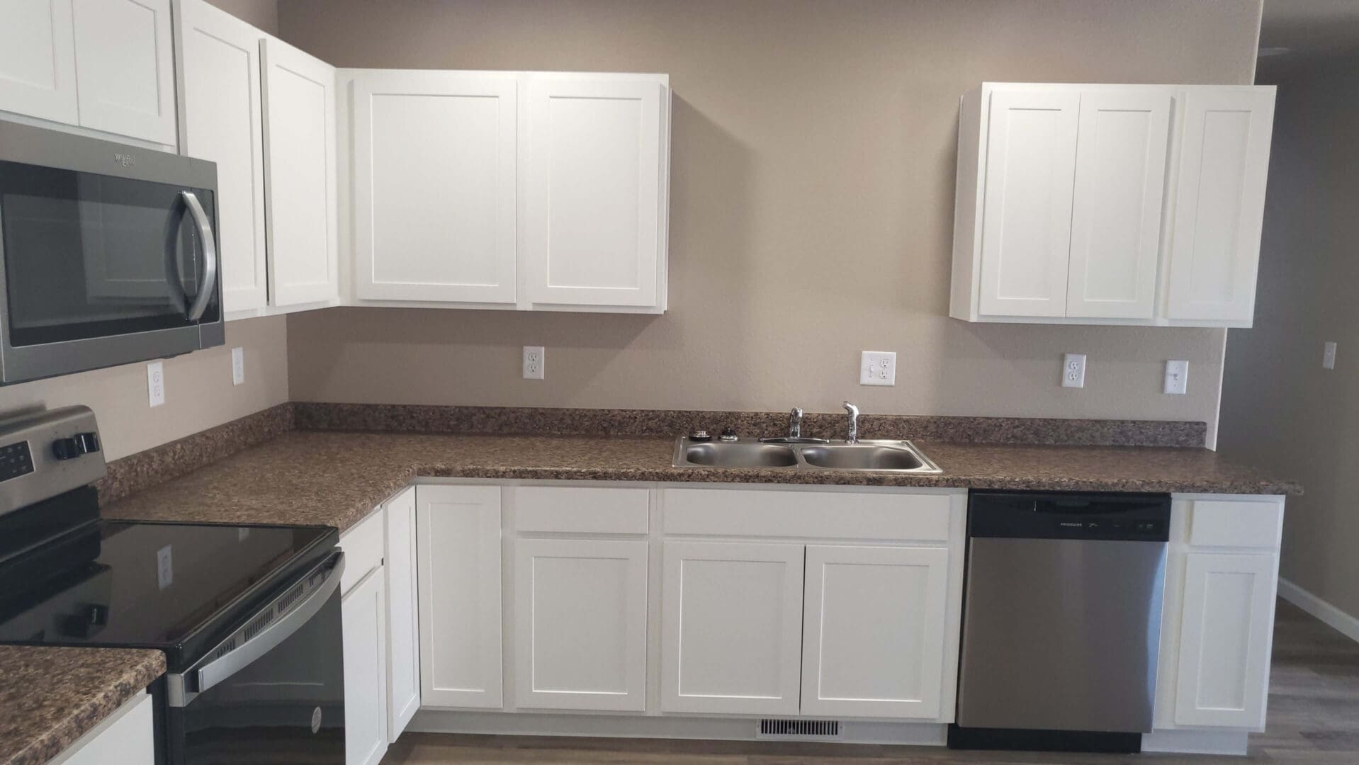 Modern kitchen with white cabinets and appliances.